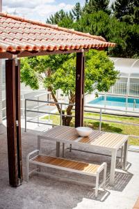 a wooden table and bench under a gazebo at casa Jone in Tomar