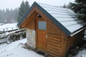 ein kleiner Schuppen mit einer Holztür im Schnee in der Unterkunft Ferienhaus Wittmann in Kurort Oberwiesenthal