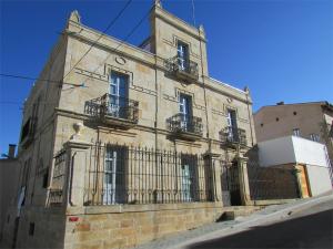 un antiguo edificio de piedra con balcones en una calle en Posada Real El Brasilero, en Saucelle