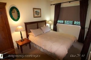 1 dormitorio con cama blanca y ventana en Birdsong Cottages - 10 Poplar Drive - Bergview Estate, en Champagne Valley