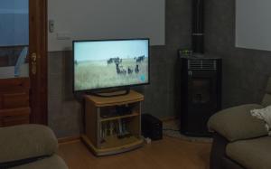 telewizor z płaskim ekranem siedzący na stojaku w salonie w obiekcie Holiday Home El Patio w mieście Fuente de Piedra