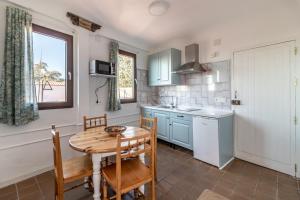 a kitchen with a wooden table and a table and chairs at Casa Quijada in Granada