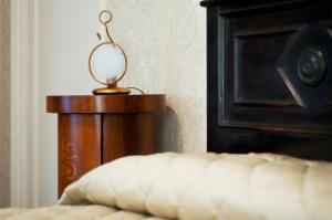 a lamp sitting on a wooden stand next to a bed at Locanda San Marco Residenza Caluri in Pistoia