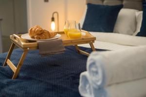 a table with a plate of pastries and a glass of orange juice at Luxury King Bed Apartment & FREE PARKING in Cambridge