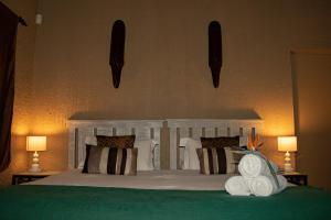 1 dormitorio con 1 cama con almohadas y 2 lámparas en Elephant's Nest, en Graskop