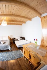 a room with a wooden table and two beds at Penzión Skorušina in Brezovica