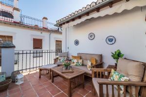 un patio con sofás y mesas en un balcón en Casa Quijada, en Granada