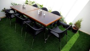 een tafel en stoelen in een kamer met gras bij The Ventura Grand Hotel in Bangalore