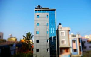 a model of a tall white building with a palm tree at The Ventura Grand Hotel in Bangalore