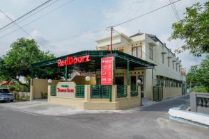 a restaurant with a sign in front of a building at RedDoorz near Stadion 45 Karanganyar in Karanganyar