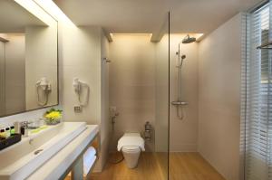 a bathroom with a toilet and a glass shower at Amari Phuket in Patong Beach