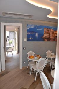 ナポリにあるB&B Federico Secondoの白い椅子と壁画のあるダイニングルーム