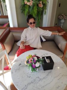 a woman sitting on a couch next to a table at A Villa Hua Hin Hotel in Hua Hin +71 photos