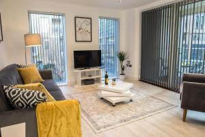 a living room with a couch and a tv at Luxury King Bed Apartment & FREE PARKING in Cambridge