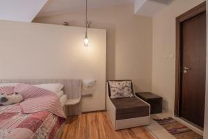 a bedroom with a bed and a chair at Апартаменти Ковачева-2 in Bansko