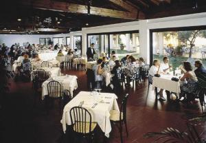 a group of people sitting at tables in a restaurant at Bungalow 2 2 in Sirmione