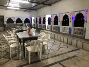 une salle à manger avec des tables, des chaises et des lumières dans l'établissement Hotel Rani Palace, à Udaipur