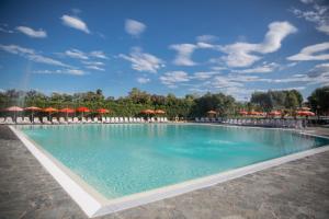 a large swimming pool with chairs and umbrellas at Bungalow 2 2 in Sirmione