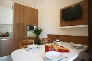 a kitchen with a table with plates and a bottle of wine at Bungalow 2 2 in Sirmione