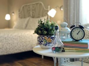 a table with a vase and a clock and books at Casa Pica in Naples