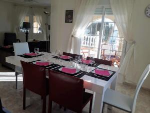 a dining room table with pink napkins and glasses at casa ronda in Rojales