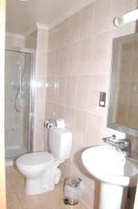 uma casa de banho com um WC branco e um lavatório. em Viking Hotel em Londres