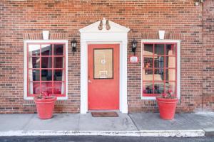 een bakstenen gebouw met een rode deur en twee ramen bij Hotel Eastin Atchison in Atchison