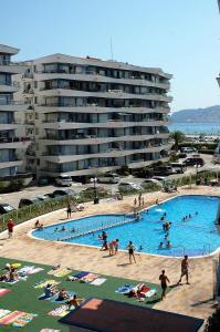 a group of people in a swimming pool next to a large building at Rocamaura I A 1-1 in L'Estartit