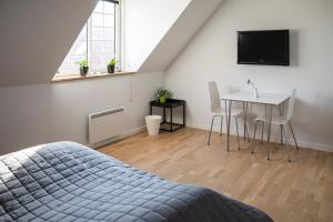 1 dormitorio con cama, mesa y TV en Kammerslusen, en Ribe