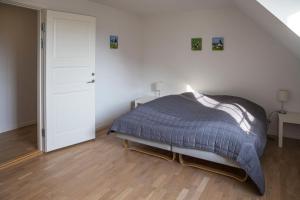 1 dormitorio con 1 cama en una habitación blanca en Kammerslusen, en Ribe
