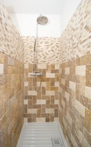 y baño con ducha y paredes de azulejos. en Alzitone, en Ghisonaccia