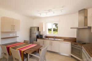a kitchen with a wooden table and a table and chairs at Alzitone in Ghisonaccia