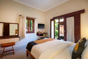 a bedroom with a large bed and a window at Nesa Sanur Bali in Sanur