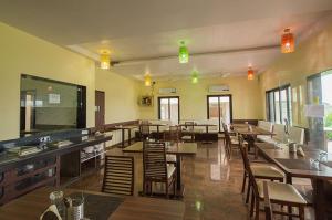 a restaurant with wooden tables and chairs and lights at Budget Inn Service Apartments - Tiger Plaza in Vengni