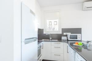cocina blanca con fregadero y microondas en Apart-Rent Apartament Bahia 0015, en Empuriabrava