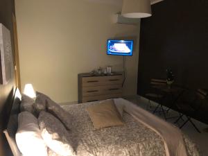 um quarto com uma cama e uma televisão na parede em B&B Relais Aeclanum em Mirabella Eclano