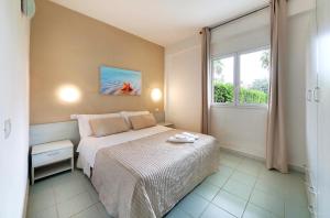 a small bedroom with a bed and a window at I Giardini di Athena- Athena Resort in Scoglitti