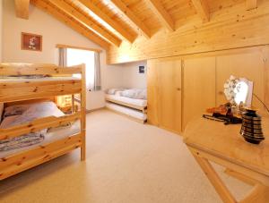 Un dormitorio con literas y un escritorio en una habitación. en Beny Duplex, en Grächen