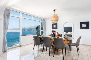 a dining room with a table and chairs and a large window at Ocean Vistas 24 in Puerto de la Cruz