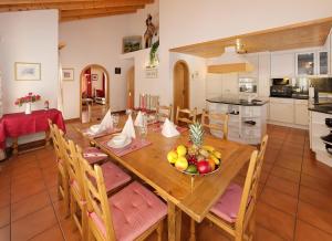 a kitchen and dining room with a table with a bowl of fruit at Beny Duplex in Grächen