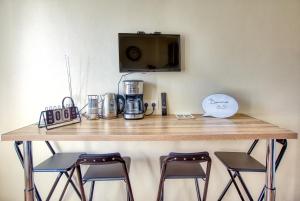 un comptoir avec deux tabourets et une table avec une cafetière dans l'établissement La Boulonnaise, à Boulogne-sur-Mer