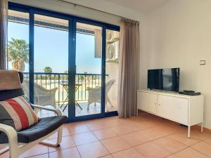 a living room with a television and a balcony at Verdemar 2 - 2309 in Playa Honda