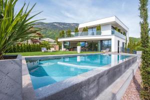a villa with a swimming pool in front of a house at Villa Aich in Appiano sulla Strada del Vino