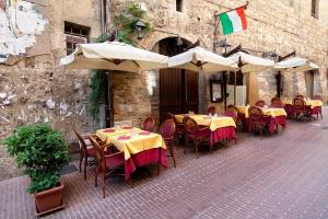 un restaurante al aire libre con mesas, sillas y sombrillas en Appartamento- Murex, en Marina di Castagneto Carducci