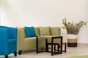 eine grüne Couch mit einem Tisch und einem blauen Stuhl in der Unterkunft Aquamarina Onyx Marina Invest in Misdroy