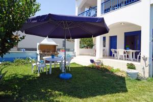 a blue umbrella in the yard of a house at Dolphins House in Paralía Avdhíron