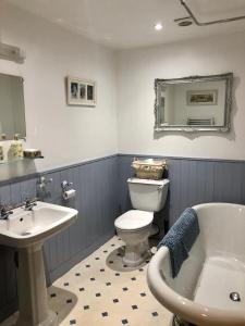 
a bathroom with a tub, toilet and sink at B&B Les Eaux de la Petite Fontaine in La Souterraine
