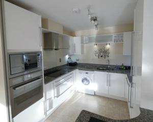 Una cocina blanca con fregadero y lavavajillas. en Luxury riverside apartment in Kendal, en Kendal
