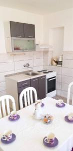 a kitchen with a table with cups and saucers on it at Apartmani Čagalj in Trogir