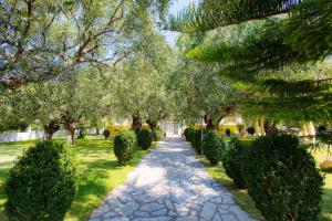 a path in a park with trees and bushes at Eleonas Apartments in Rizá